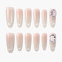 Set of nude pink press-on nails with glossy finish and large rhinestone accents
