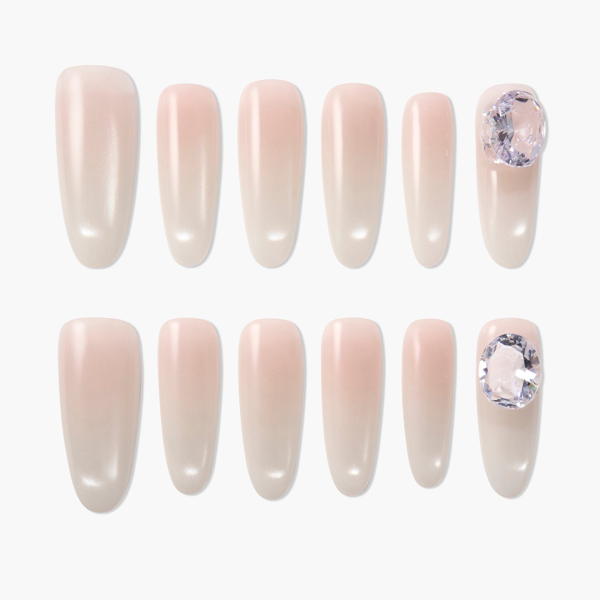 Set of nude pink press-on nails with glossy finish and large rhinestone accents