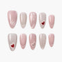 Handmade press-on nails in pink and nude tones with heart and polka dot designs, glossy finish
