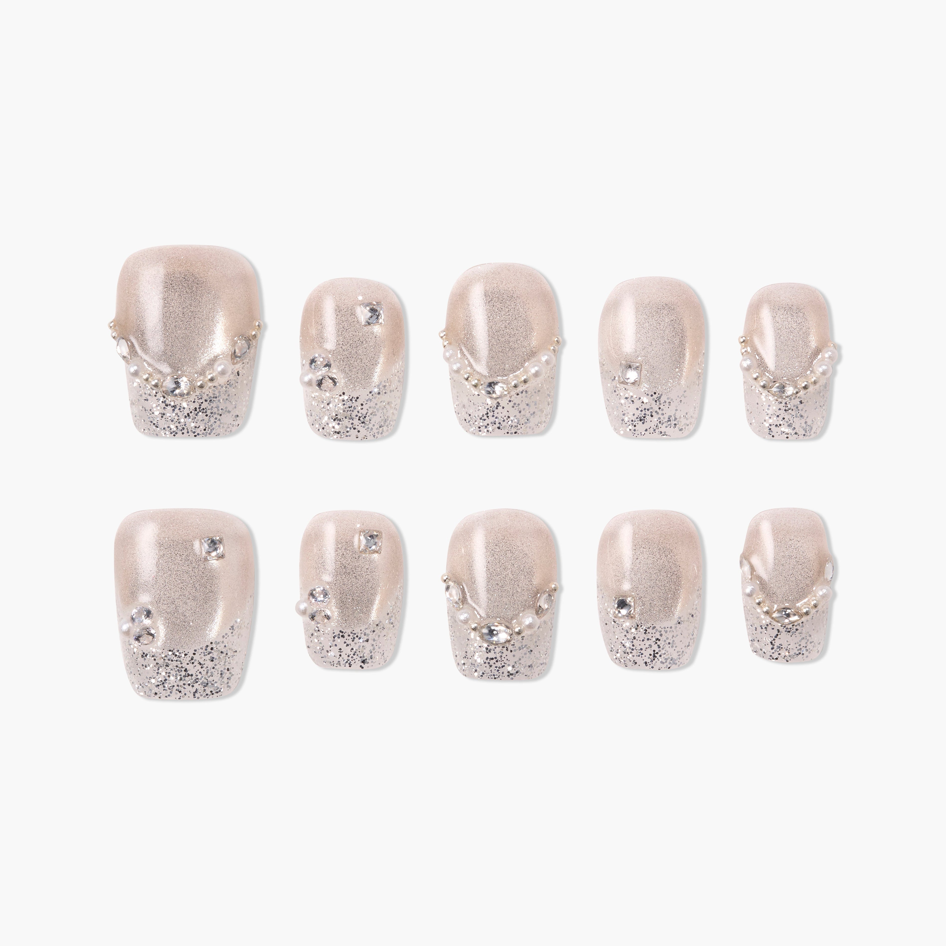 Handmade press-on nails with nude base, silver glitter tips, pearls, and rhinestone accents