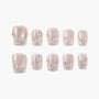 Handmade press-on nails with nude base, silver glitter tips, pearls, and rhinestone accents