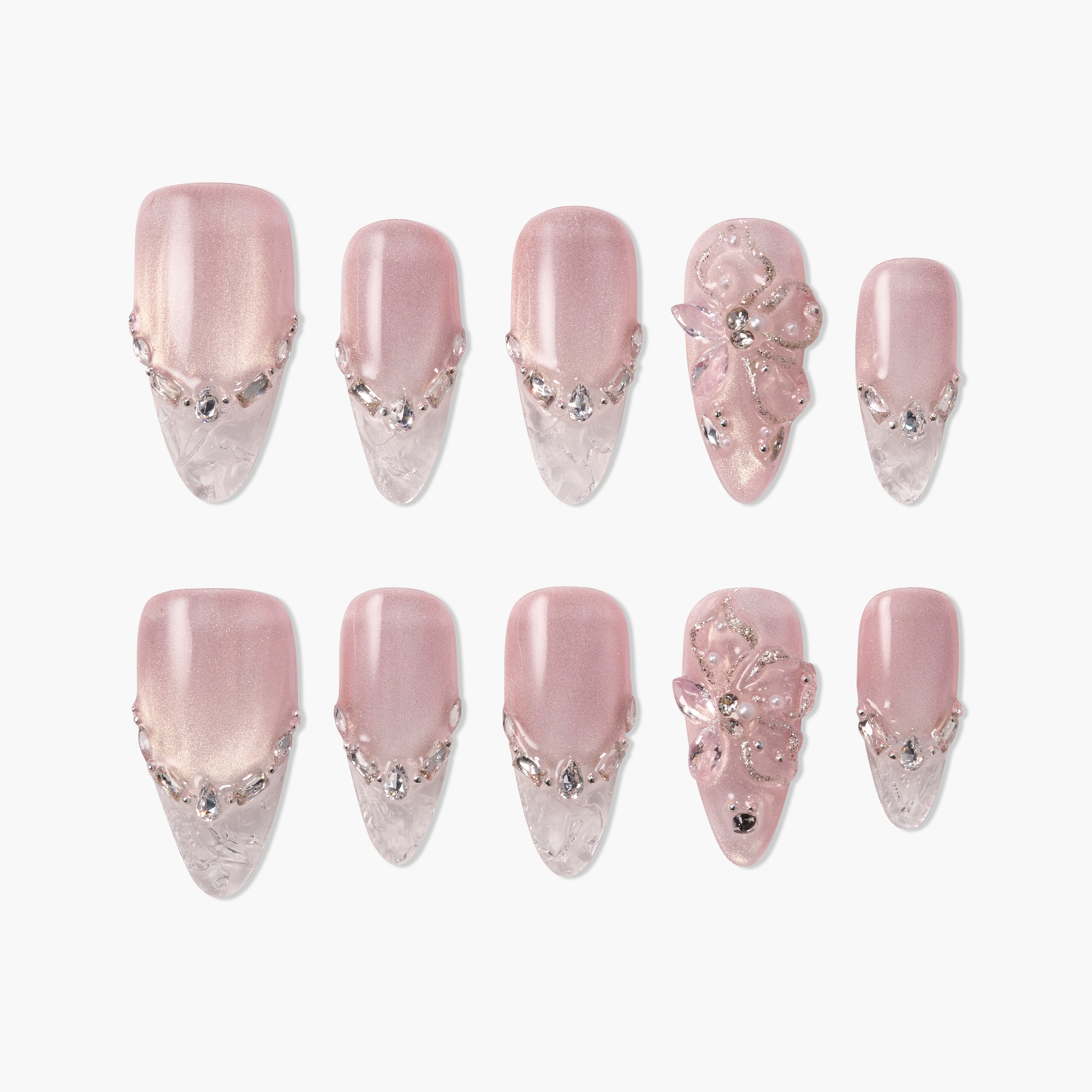 Pink and clear press-on nails with rhinestone accents and 3D floral designs on white background