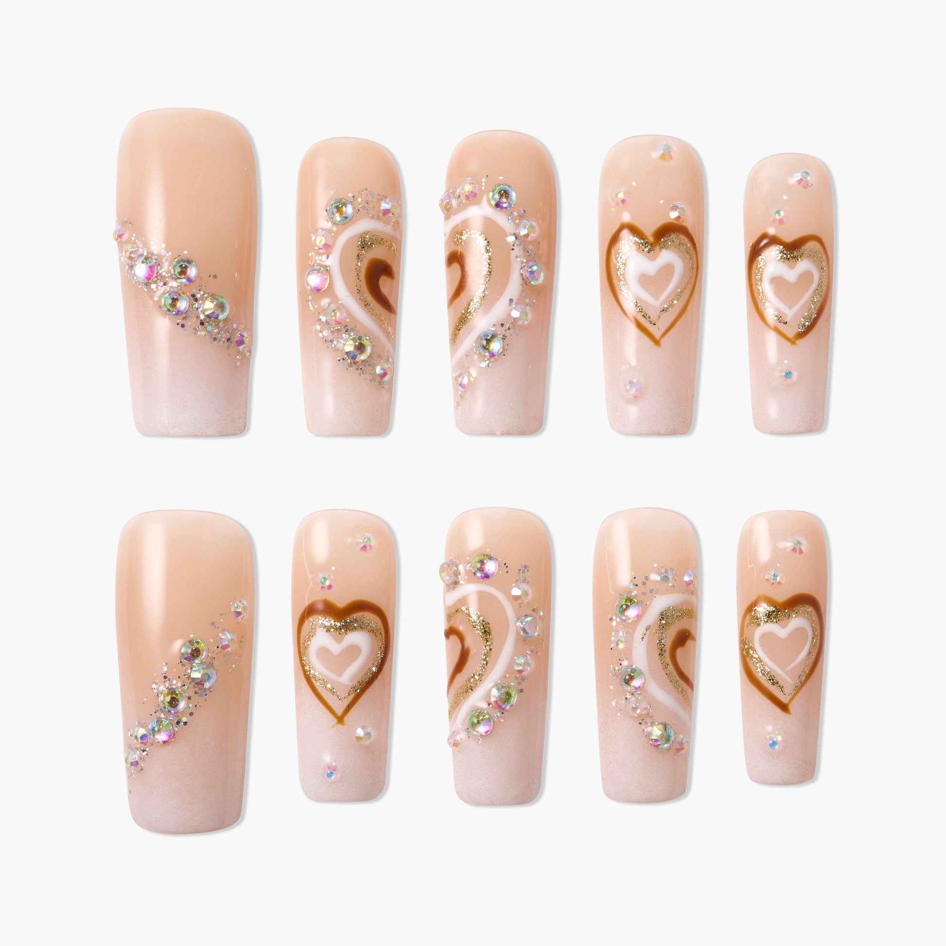 Nude pink press-on nails with gold heart designs and sparkling rhinestone accents