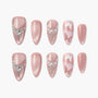 Pink press-on nails with pearl and gem accents, butterfly and glitter nail art designs