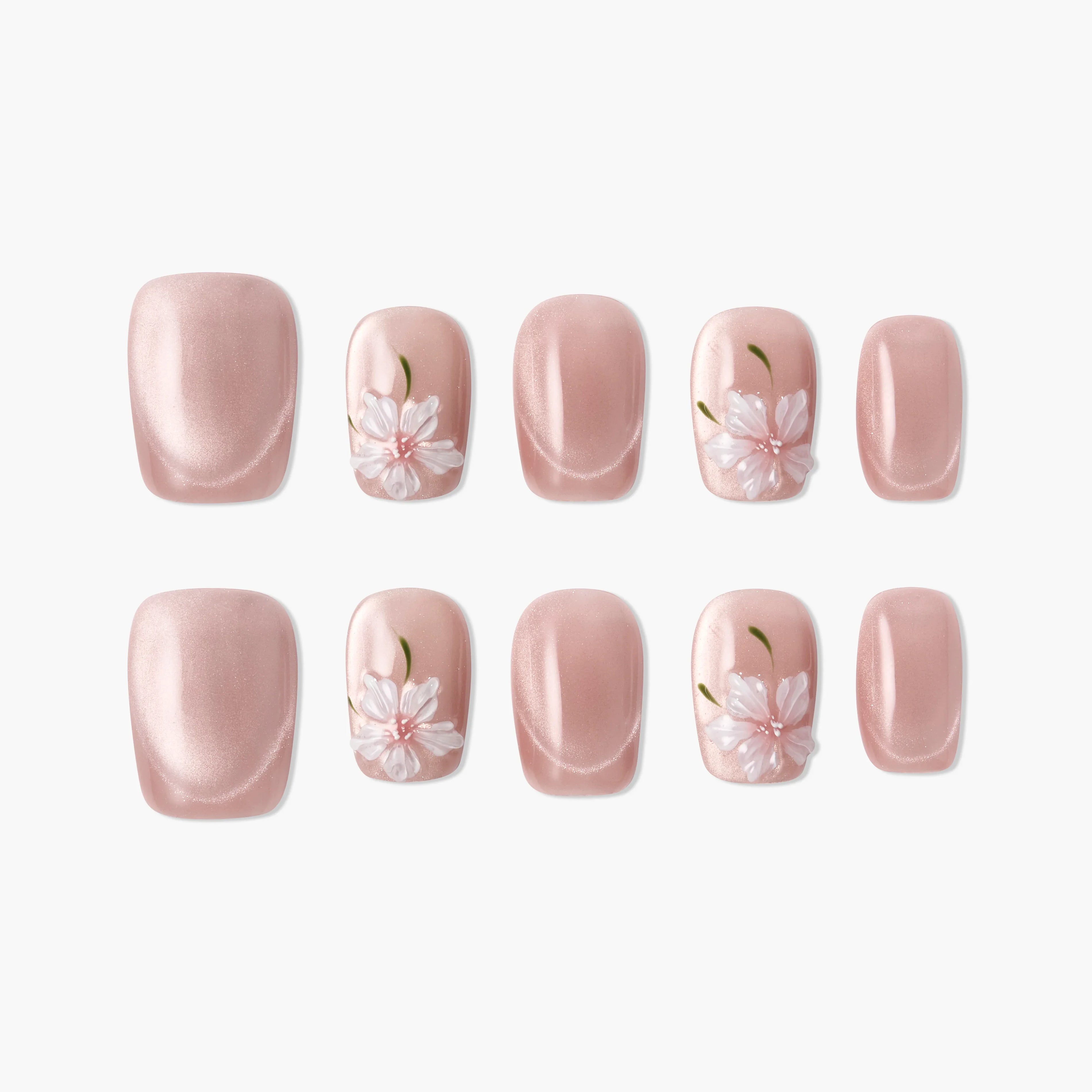 Pink press-on nails with white 3D floral designs and green accents, glossy finish