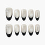 Handmade press-on nails with black French tips and white snowflake designs, winter nail art.