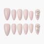 Set of pink almond-shaped press-on nails, with accent nails adorned with pearls and gems.