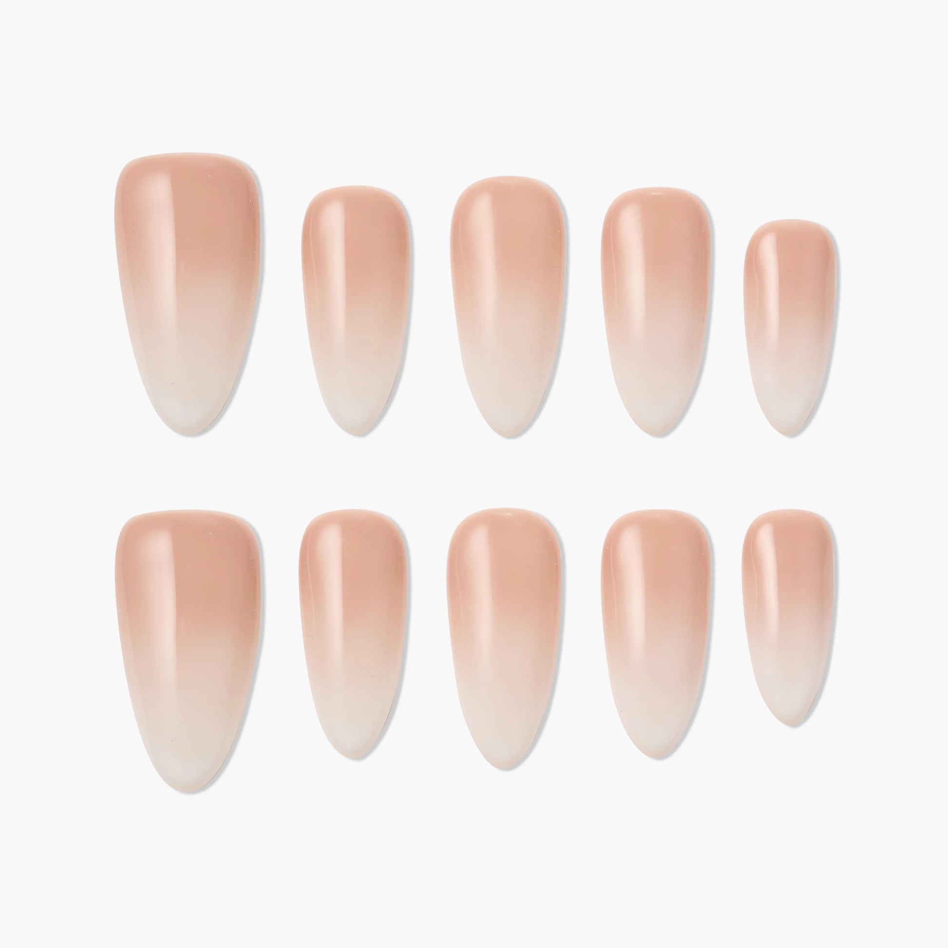 Set of nude ombre press-on nails in an almond shape, arranged on a white background.
