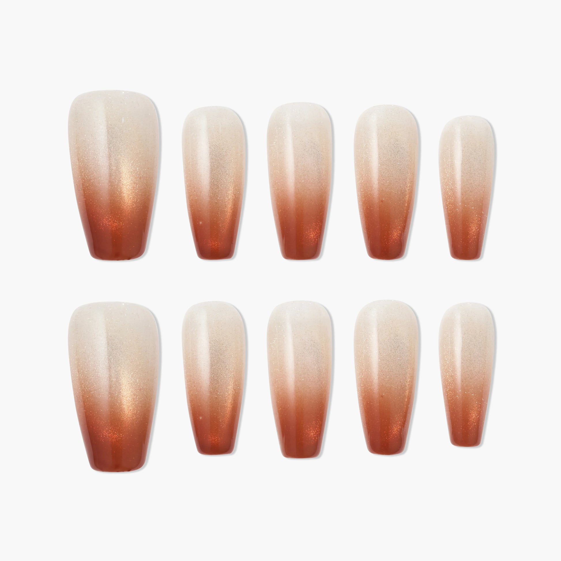 Set of handmade press-on nails with shimmery brown to nude ombre design on white background