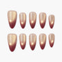 Set of ombre press-on nails with gold and burgundy gradient design on white background.