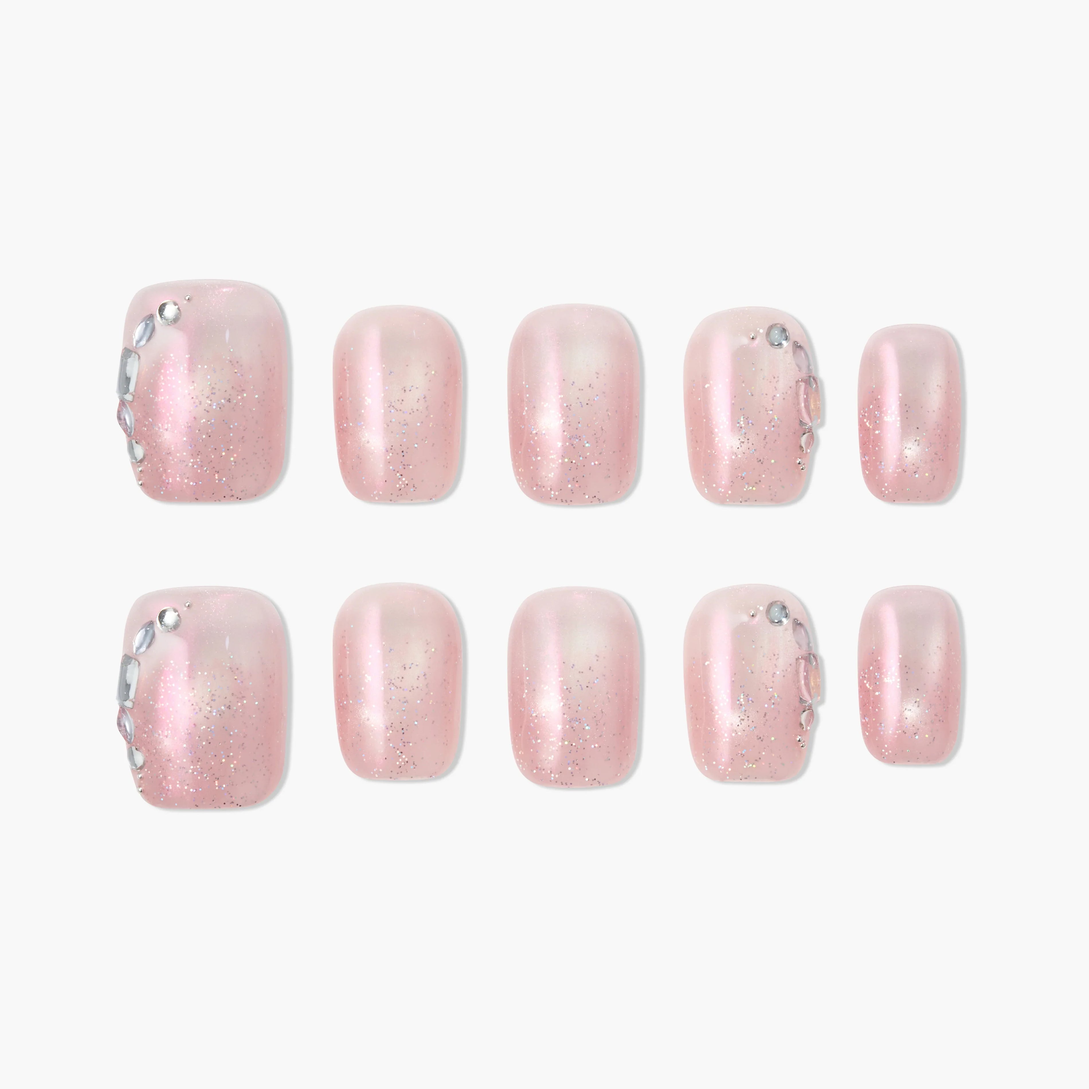 Handmade press-on toe nails with pink glitter and rhinestone accents, arranged on white background.