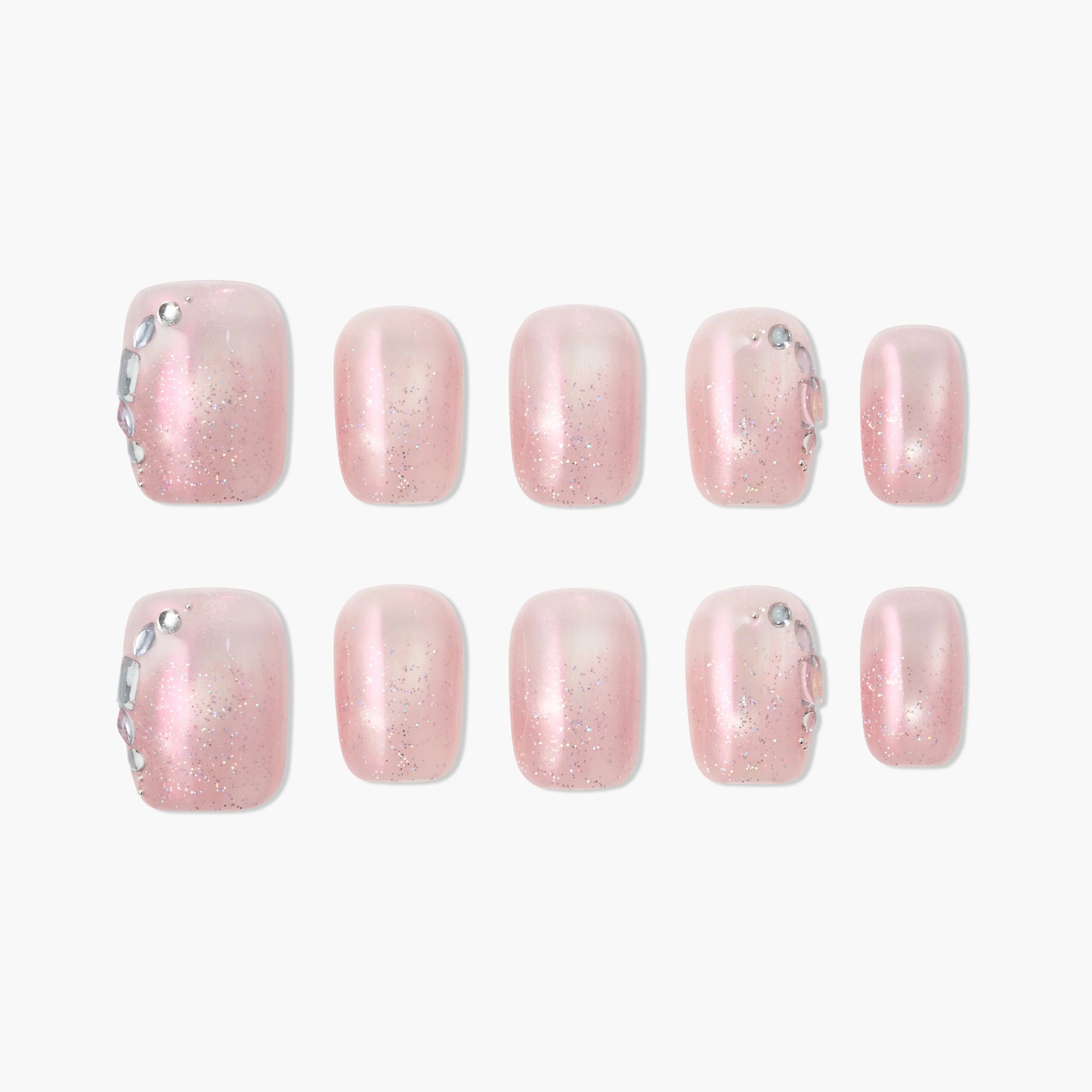 Handmade press-on toe nails with pink glitter and rhinestone accents, arranged on white background.