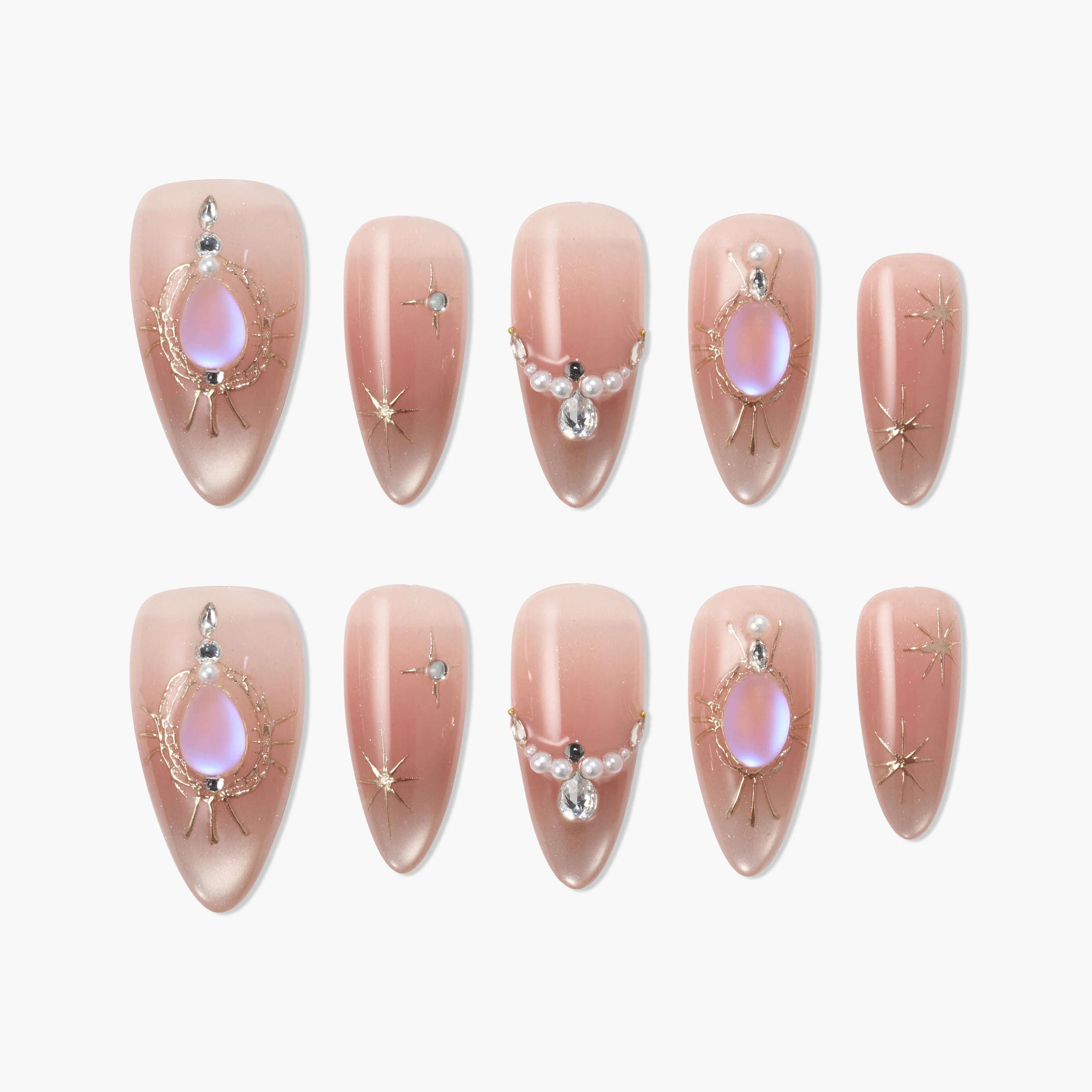 Handmade almond press-on nails with nude ombre, iridescent gems, and gold star accents