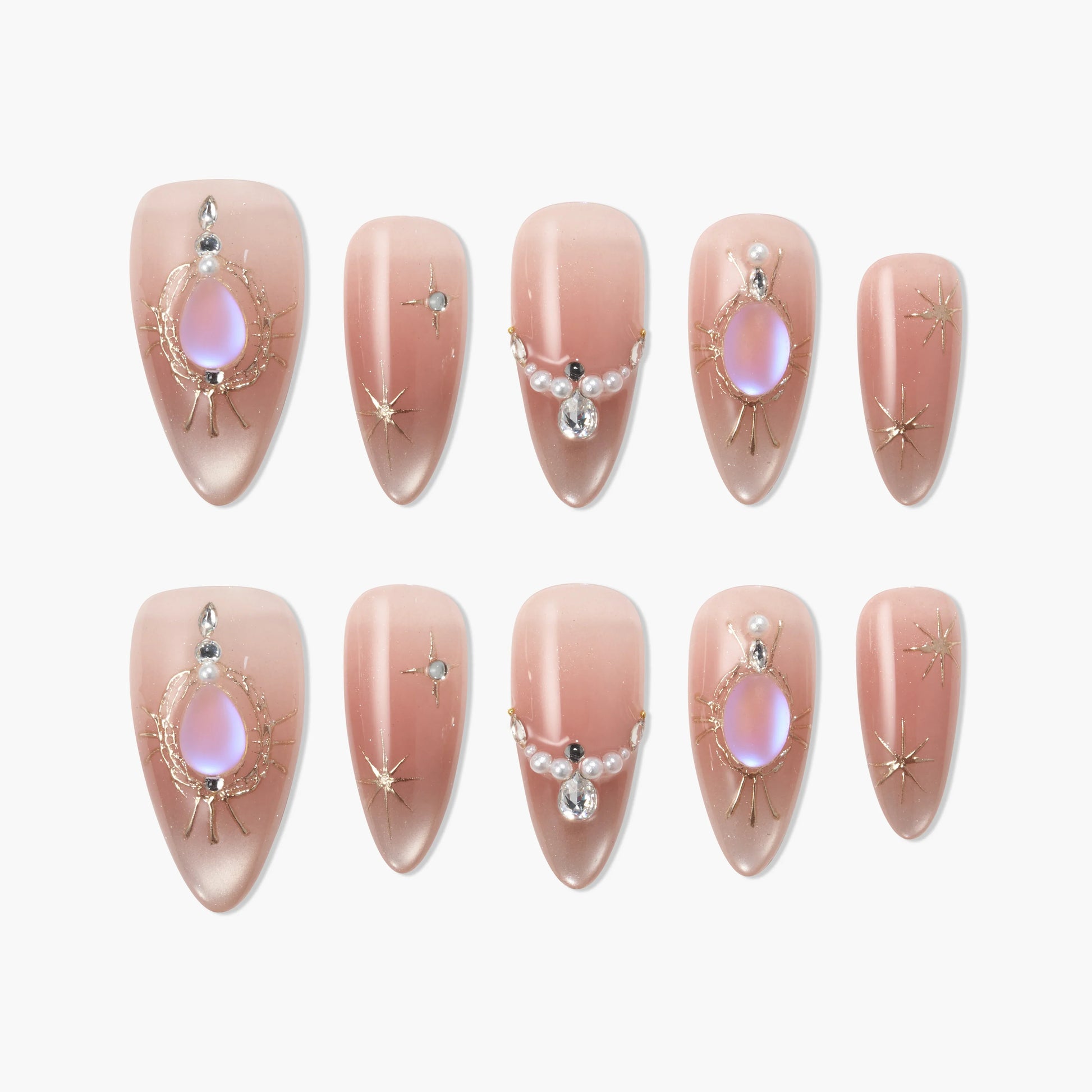 Handmade almond press-on nails with nude ombre, iridescent gems, and gold star accents