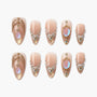 Elegant nude press-on nails with gold, gem, pearl, and opal embellishments in ornate designs.