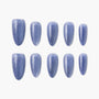 Set of oval blue glitter press-on nails arranged on a white background
