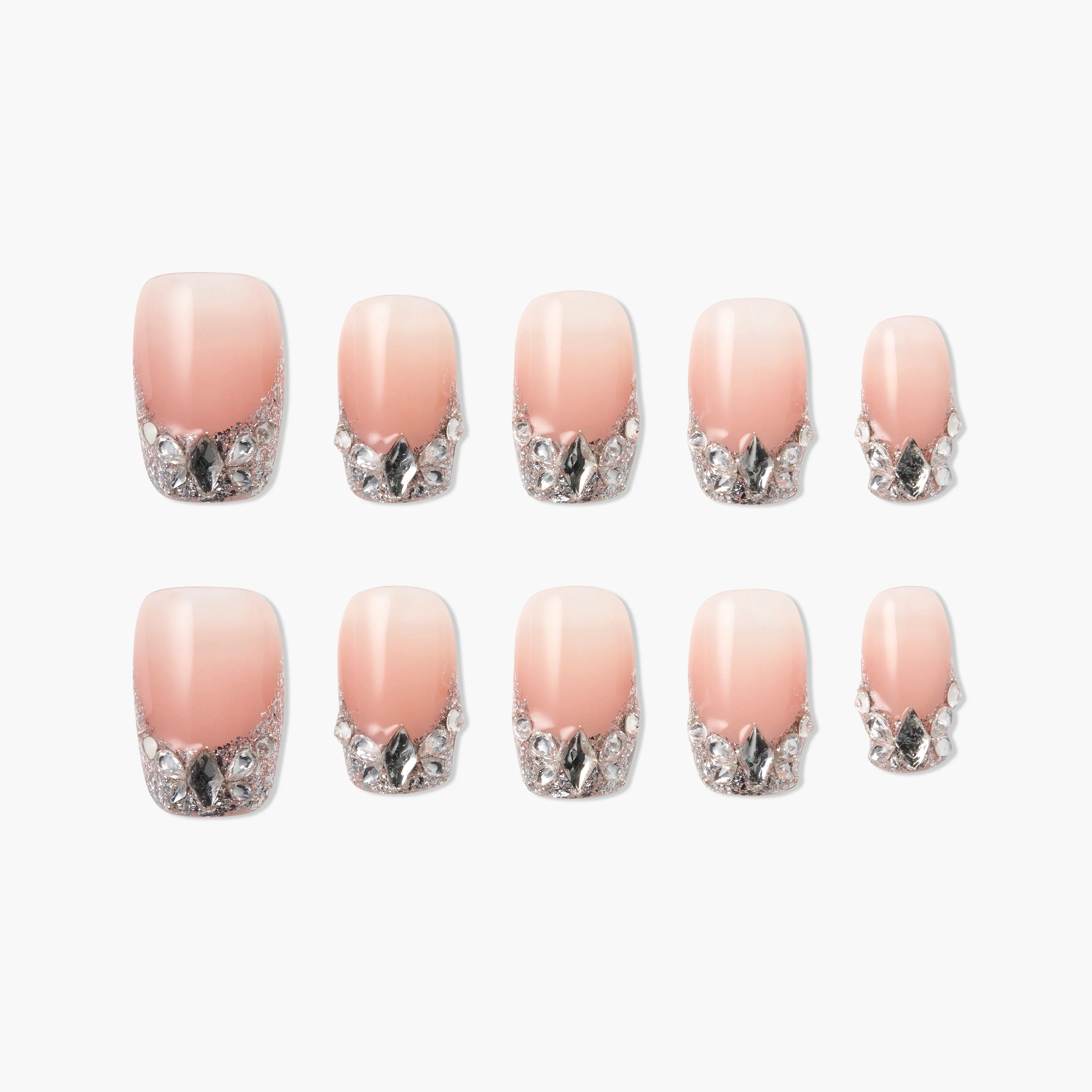 Set of pink ombre press-on nails with silver glitter and gem accents, arranged on white background