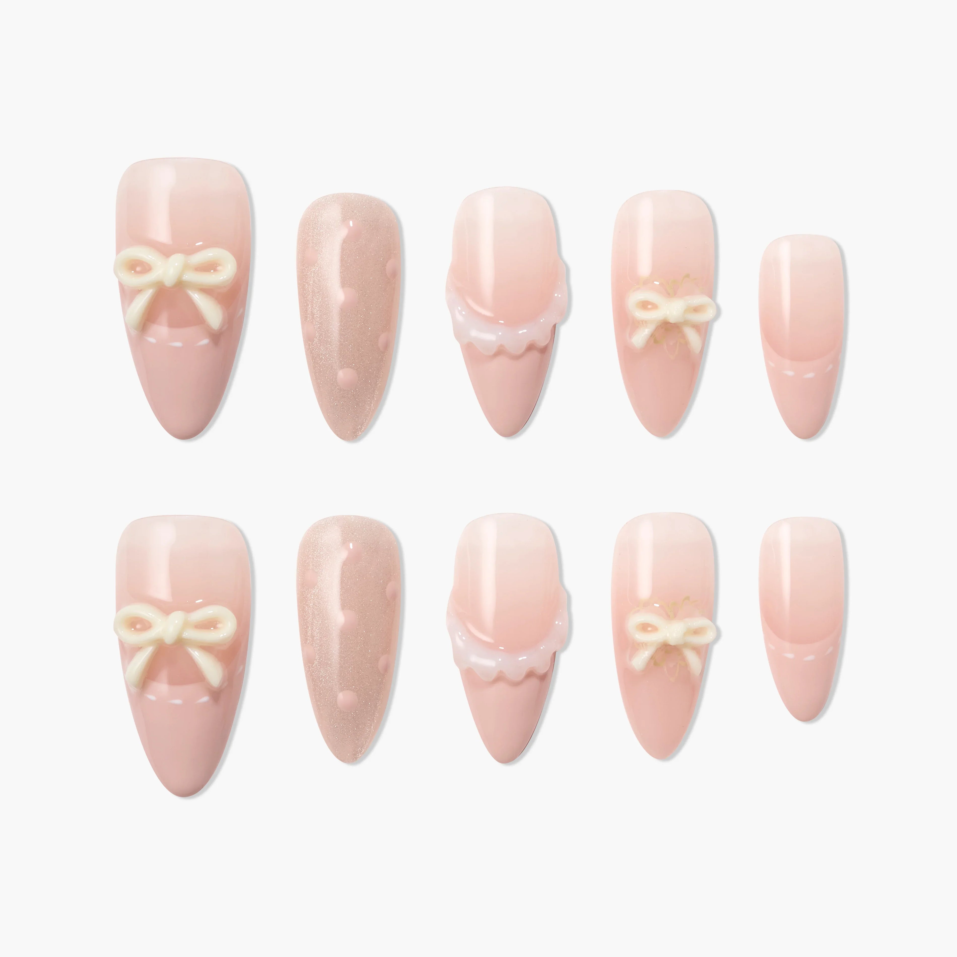 Pink press-on nails with 3D bows, polka dots, and scalloped designs on white background