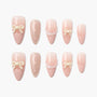 Pink press-on nails with 3D bows, polka dots, and scalloped designs on white background