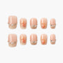 Handmade press-on nails with nude and gold glitter tips, pearl and crystal accents, and floral designs