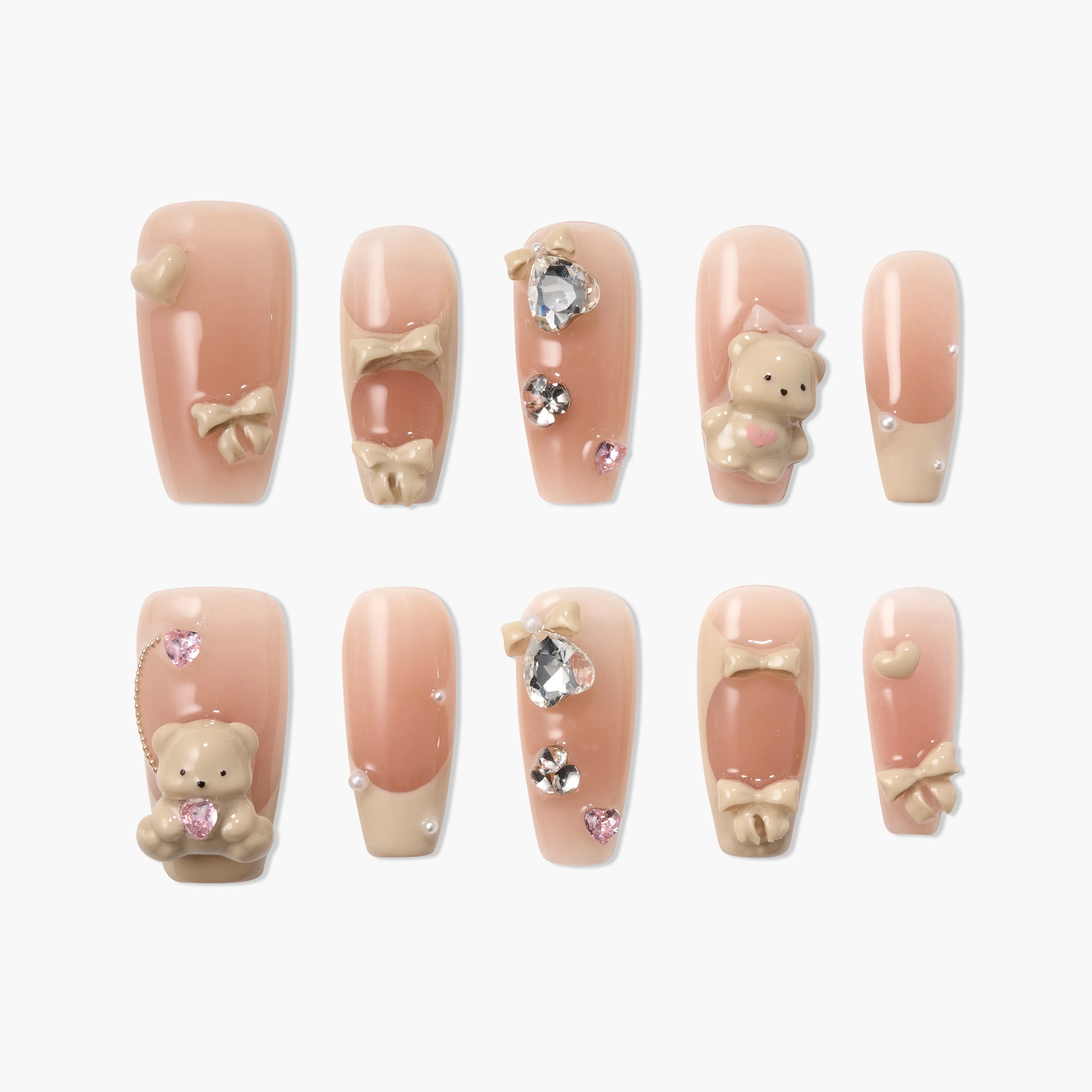 Handmade press-on nails with nude pink base, 3D bows, bear charms, and crystal rhinestones