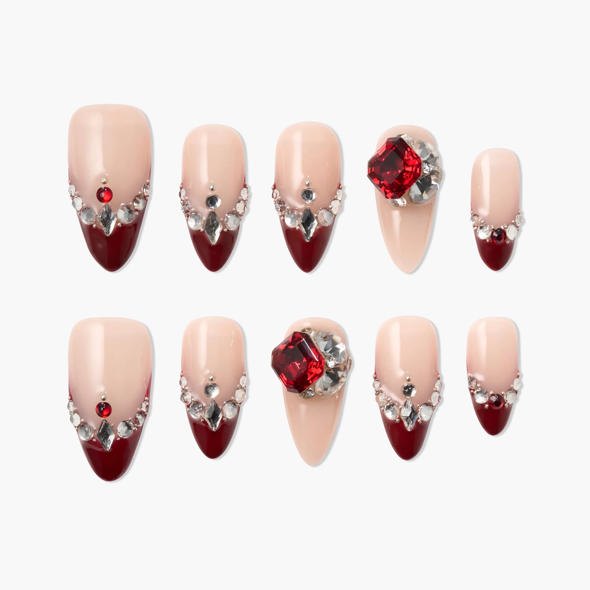 Handmade press-on nails with nude and deep red tips, adorned with rhinestones and gems.