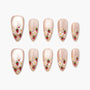 Handmade press-on nails with nude base, strawberry and flower nail art design, arranged on white background