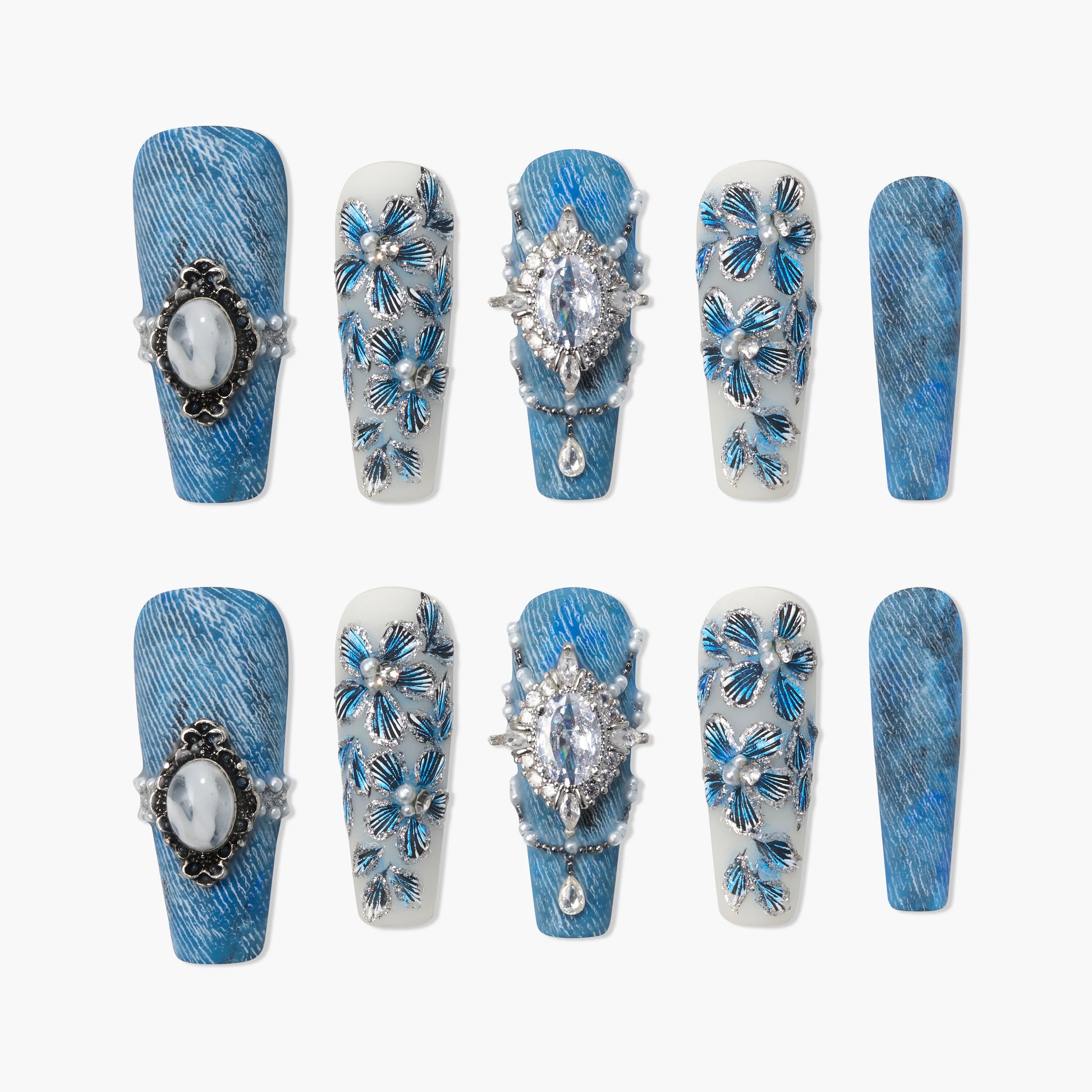Blue press-on nails with gemstone accents and floral 3D designs, denim texture style