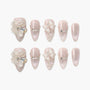 Pink glitter press-on nails with 3D floral and bow designs, pearls, and rhinestones accents.