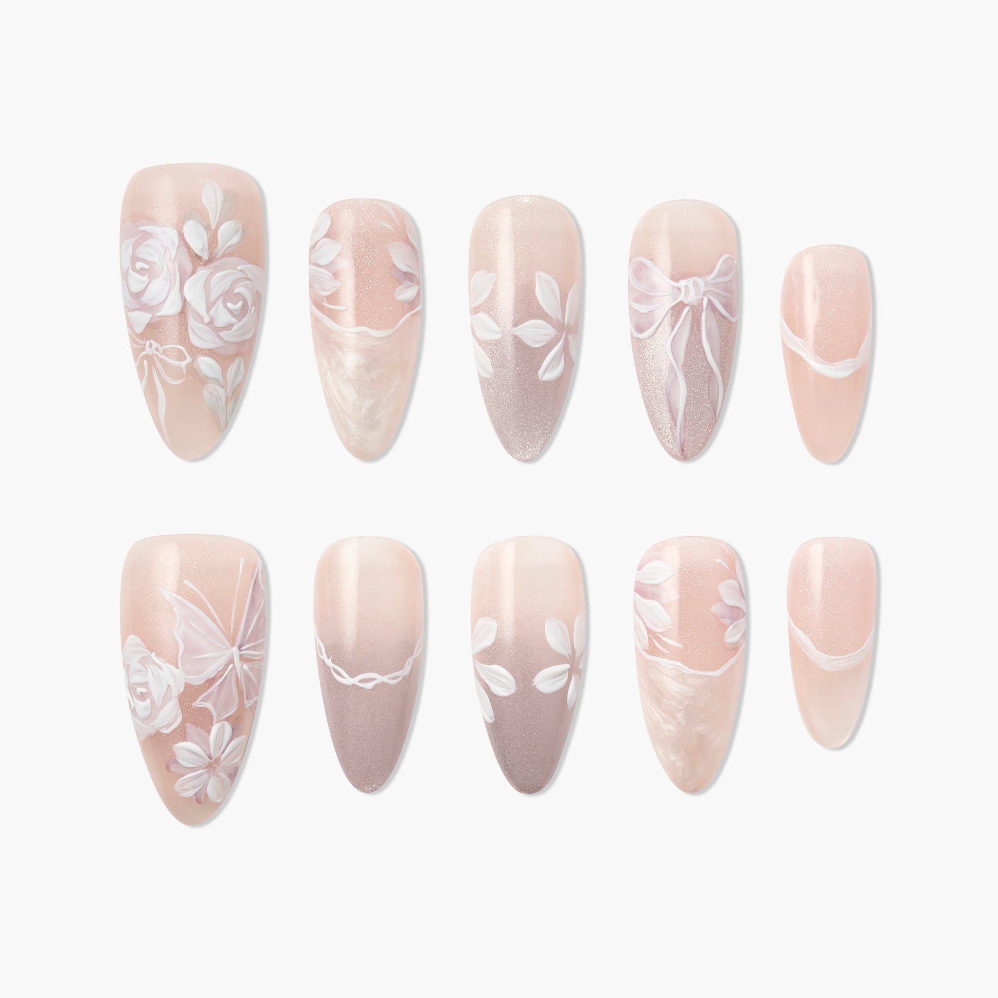 Handmade press-on nails in soft pink with white floral, leaf, and bow nail art designs.