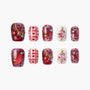 Handmade Christmas press-on nails with red snowflakes, hearts, and 3D Christmas tree designs