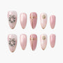 Set of pink press-on nails with gold accents, bow, wreath, and pearl decorations.