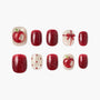 Red and glittery apple-themed press-on nails set with bow and polka dot designs on white background