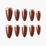 Set of glossy brown press-on nails with metallic gold tips arranged on white background