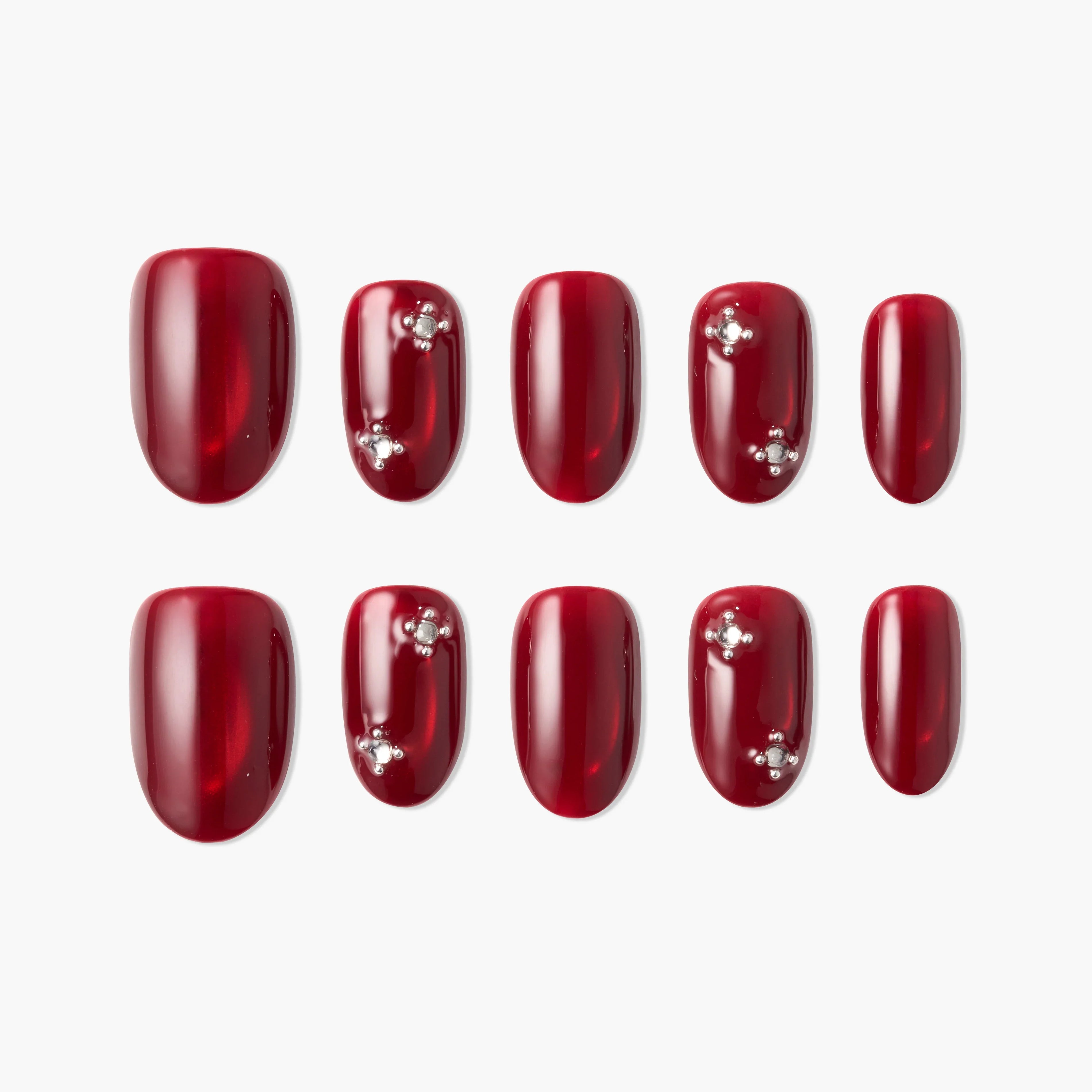 Set of glossy red press-on nails with rhinestone accents, arranged on a white background.