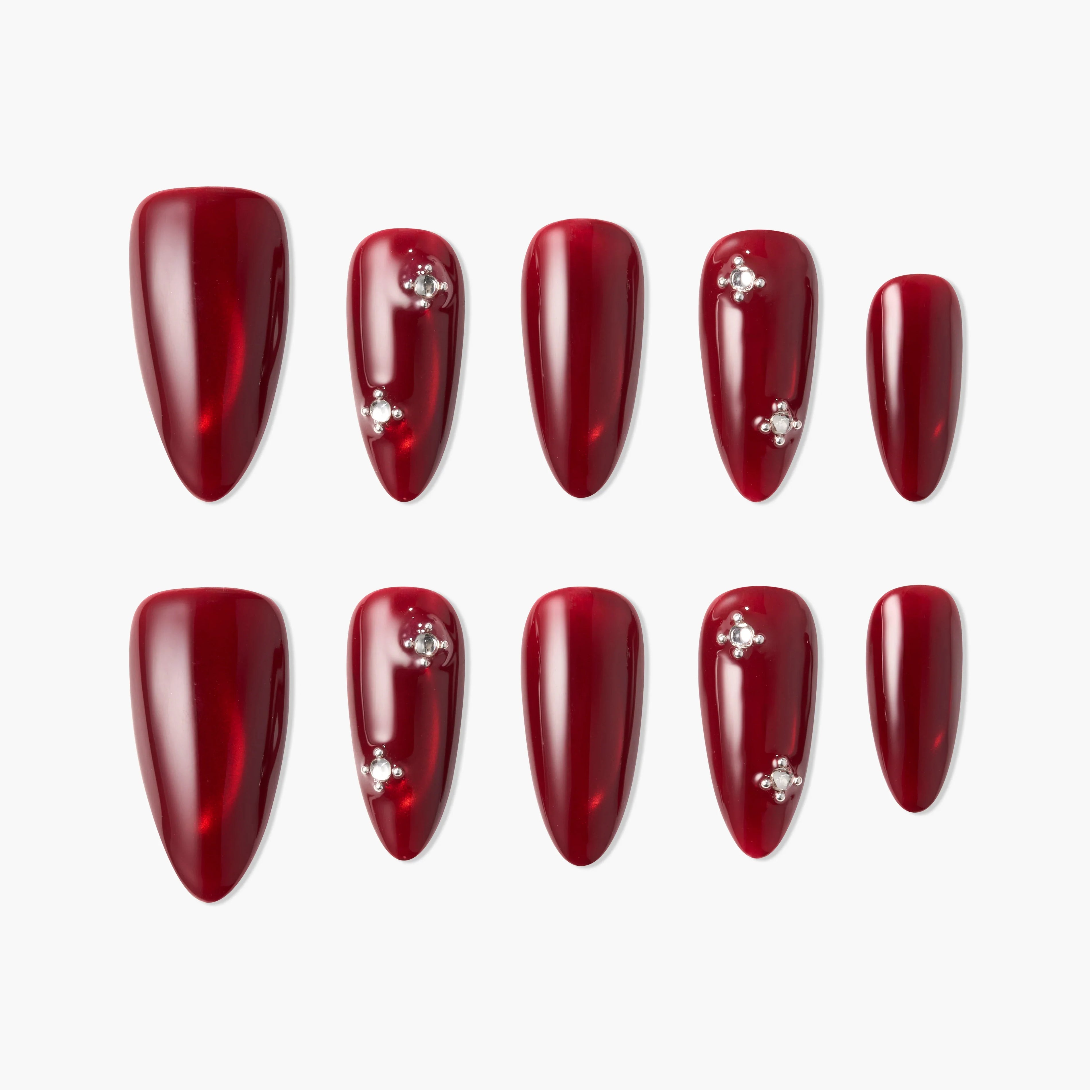 Glossy red press-on nails set with rhinestone accents on white background