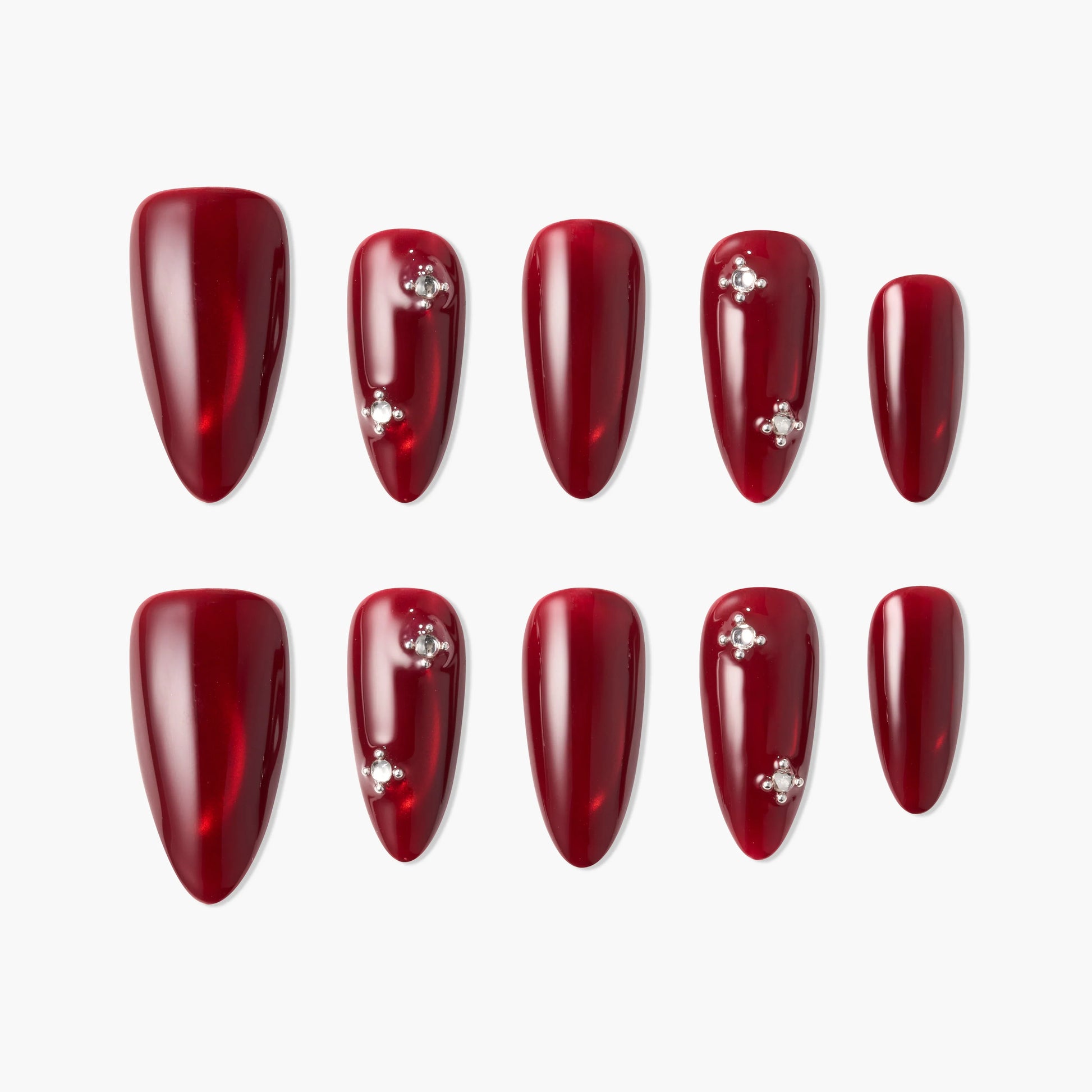 Glossy red press-on nails set with rhinestone accents on white background