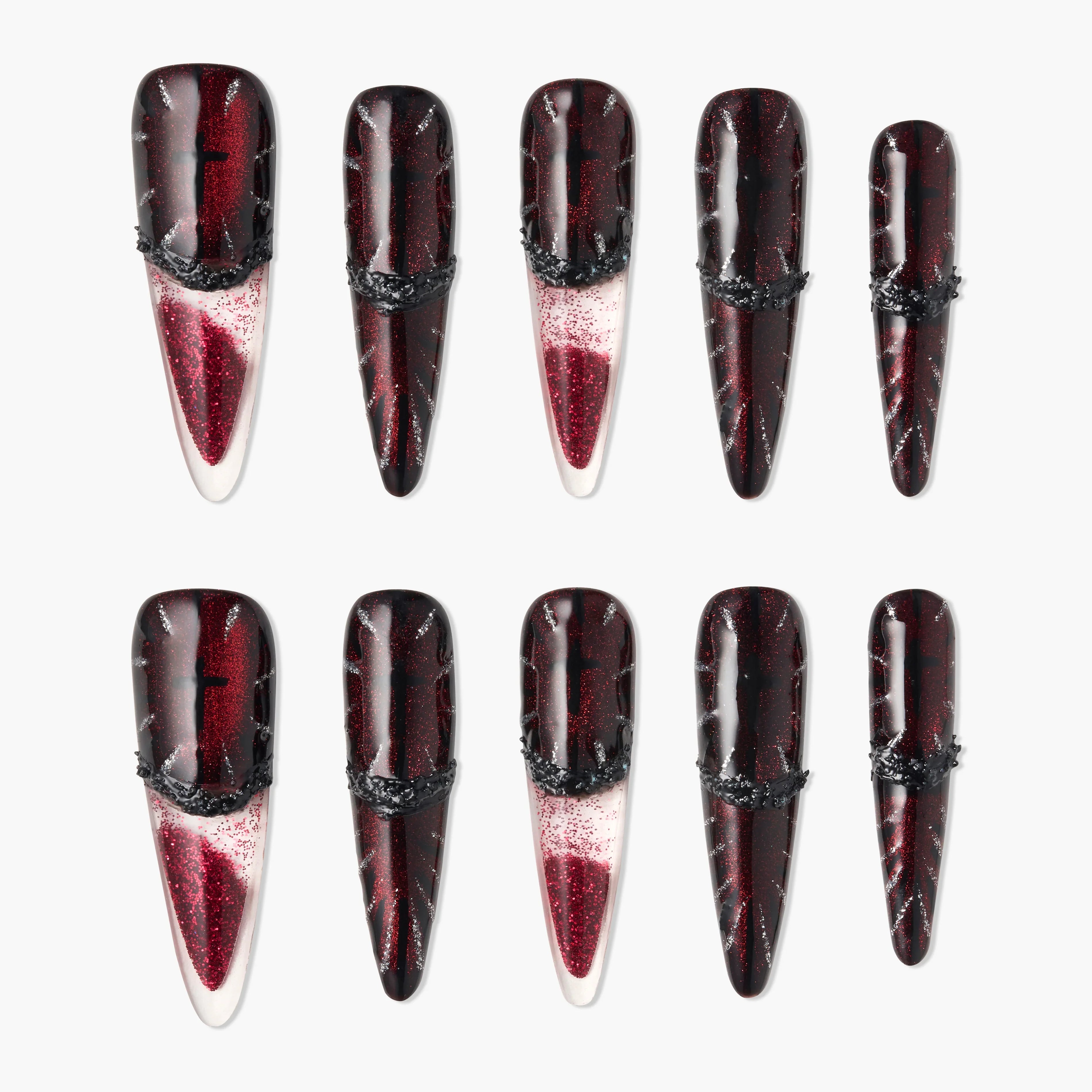Glossy red and black stiletto press-on nails with glitter and textured black accents, arranged on white background.