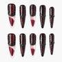 Glossy red and black stiletto press-on nails with glitter and textured black accents, arranged on white background.