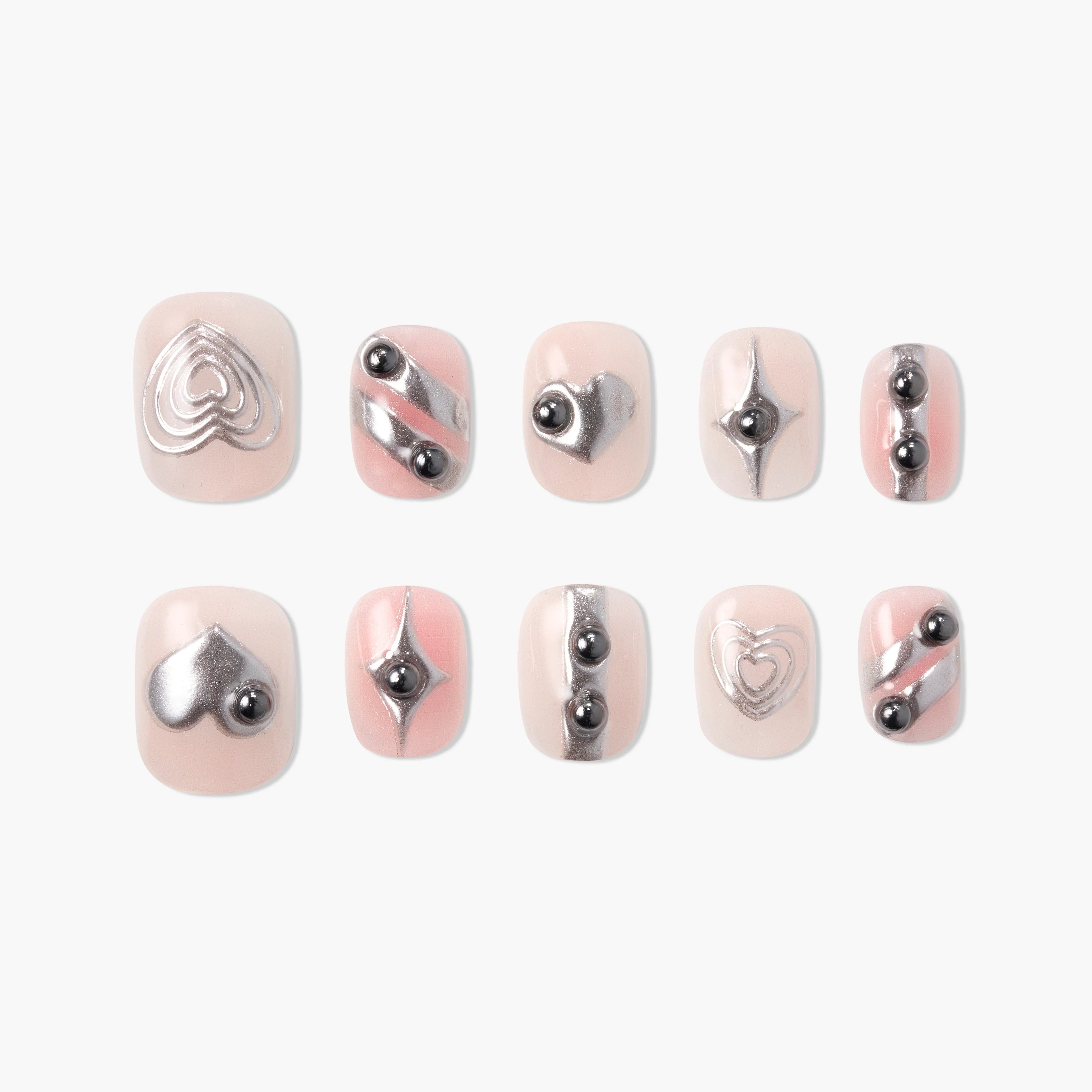 Press-on nails set with metallic silver heart, stripe, and stud accents on pink nude base.