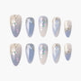 Handmade press-on nails with pastel blue, floral accents, pearl embellishments, and metallic details