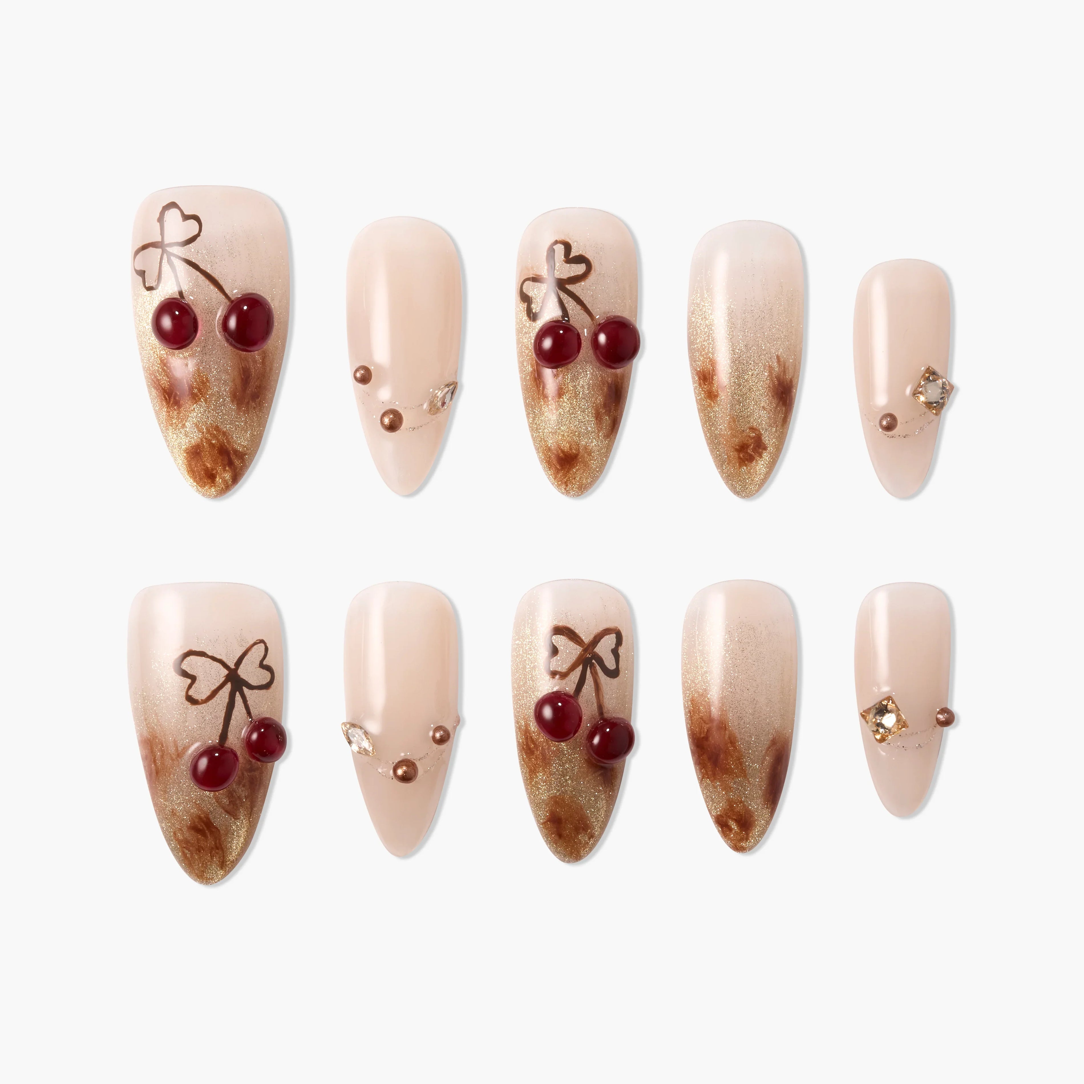Handmade press-on nails with nude and gold marble design, cherry art, and gem accents.
