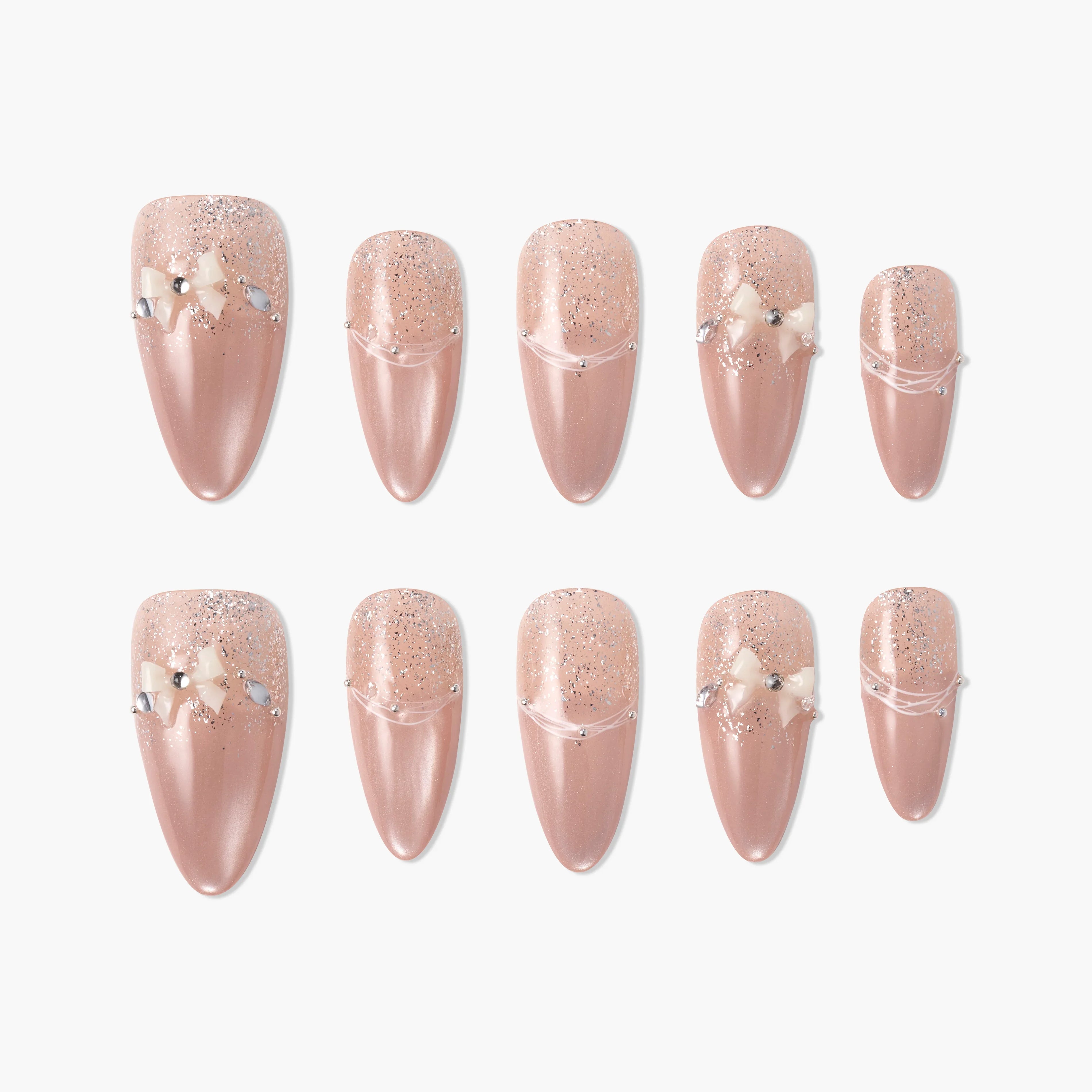 Set of handmade nude pink press-on nails with glitter, pearl accents, and small 3D bows