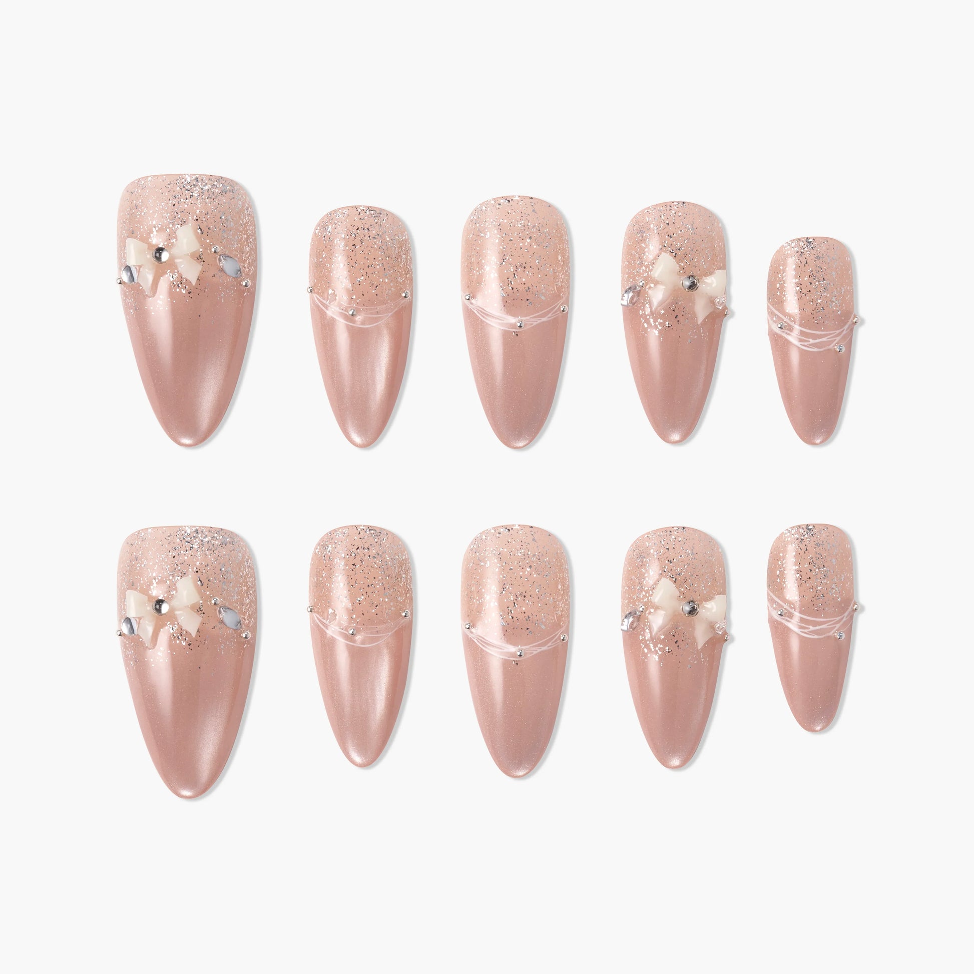 Set of handmade nude pink press-on nails with glitter, pearl accents, and small 3D bows