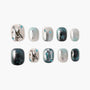 Handmade press-on nails with glitter, star, and guitar designs in silver, blue, and black.