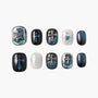 Handmade press-on nails with metallic cross and heart designs in black, teal, and silver tones.