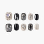 Handmade press-on nails with black, silver, and nude spider web and pearl accents.