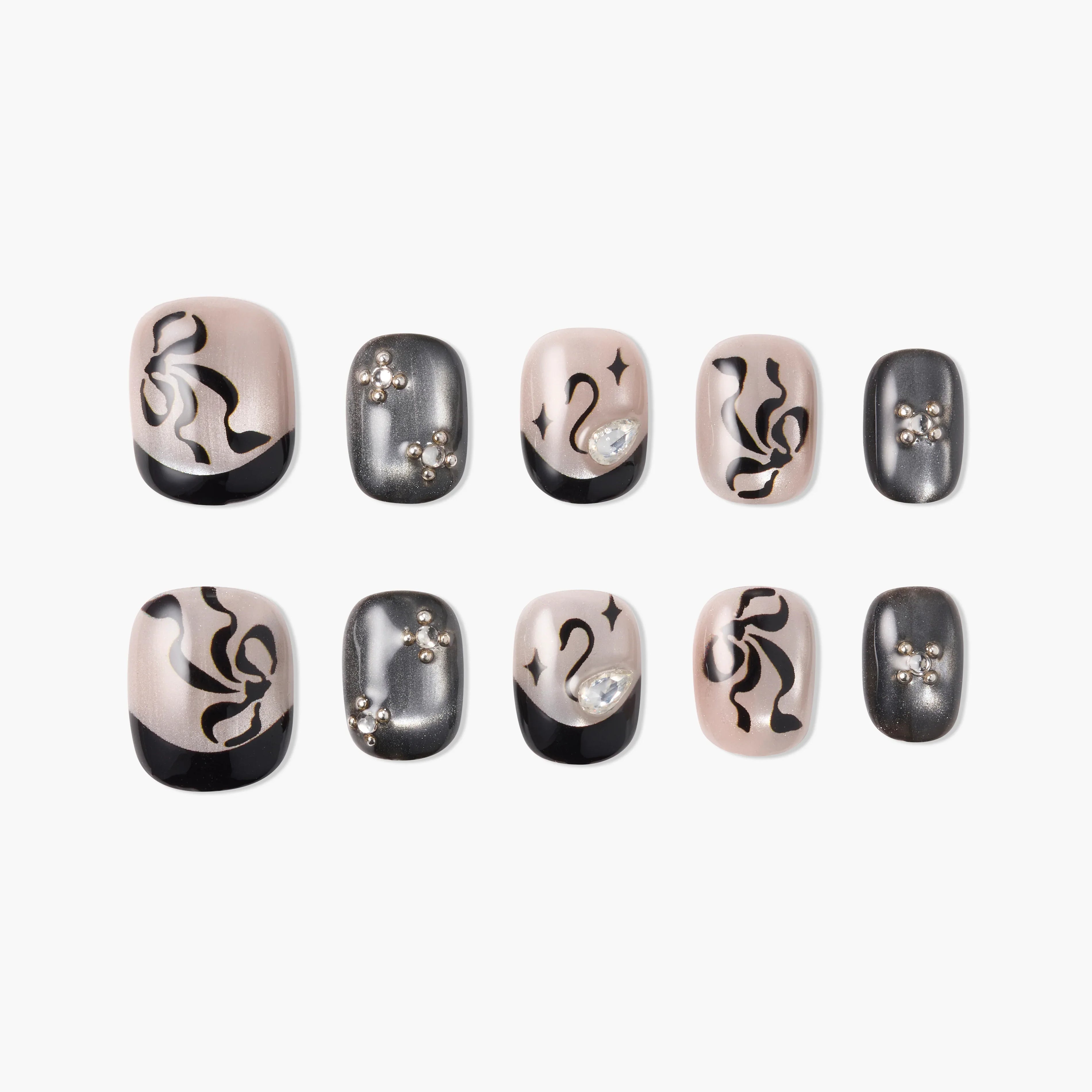 Handmade press-on nails with black abstract designs, rhinestone accents, and nude bases.