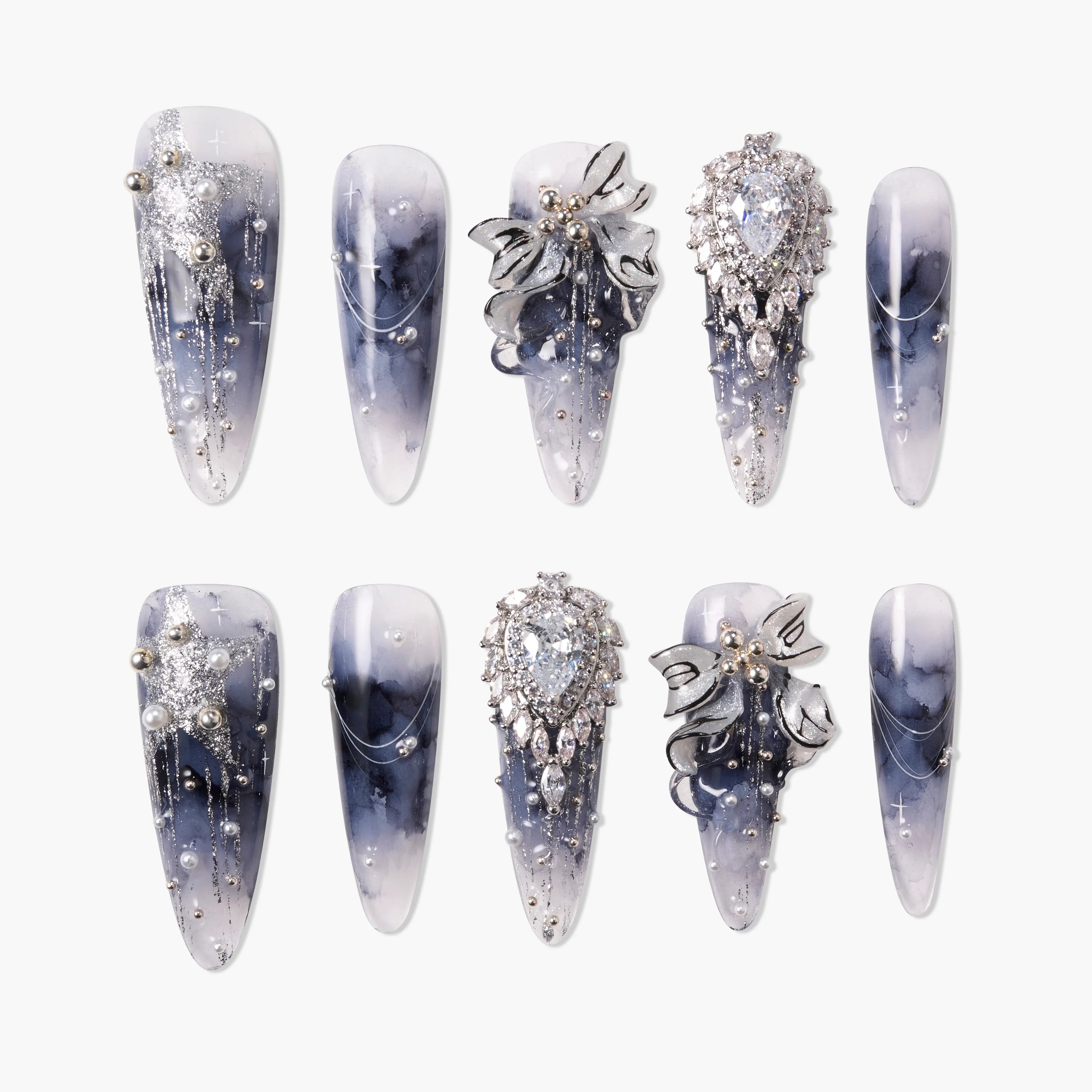 Handmade press-on nails with black and white marble design, metallic bow and rhinestone accents