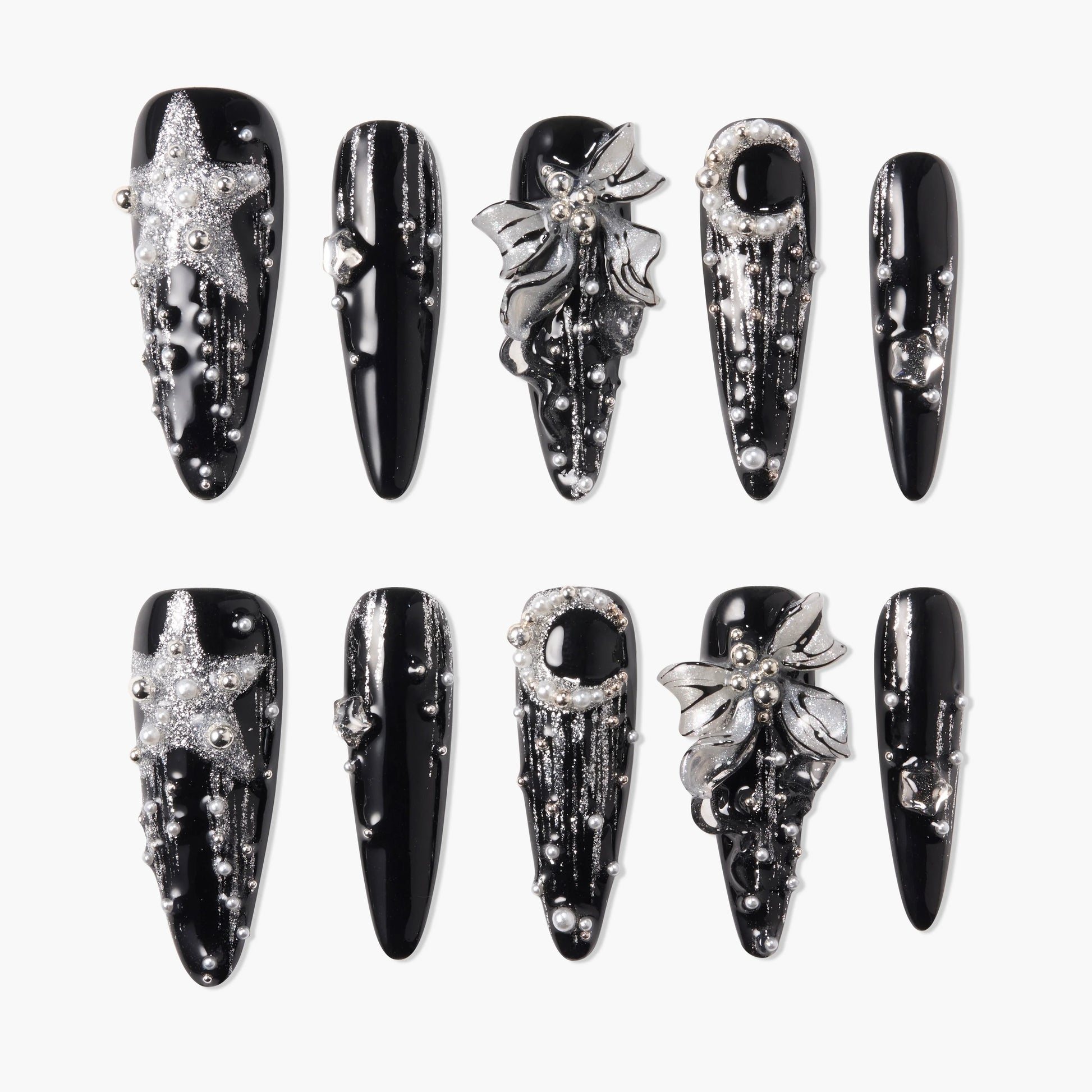 Black press-on nails with silver 3D stars, flowers, pearls, and glitter accents, arranged on a white background.